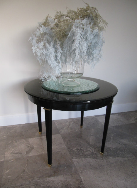 A round 1950s ebonised table